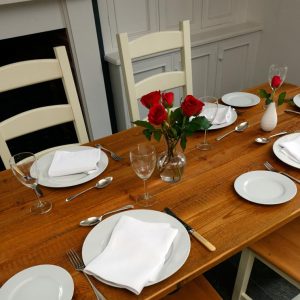 plates, cutlery and glasses on set reclaimed wood table