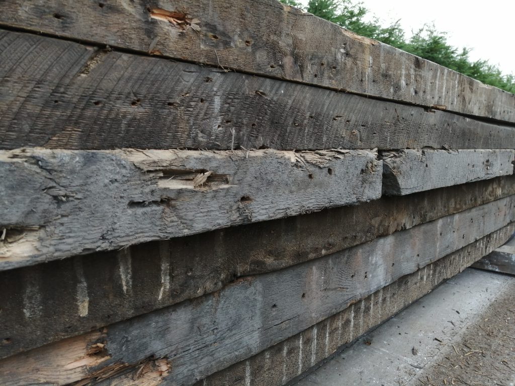 Reclaimed wooden beams for use in our workshop