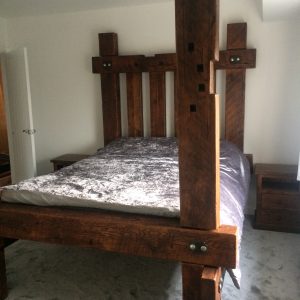 A rustic medieval bed frame made from reclaimed wood, with a no-nonsense design that highlights the natural grain.