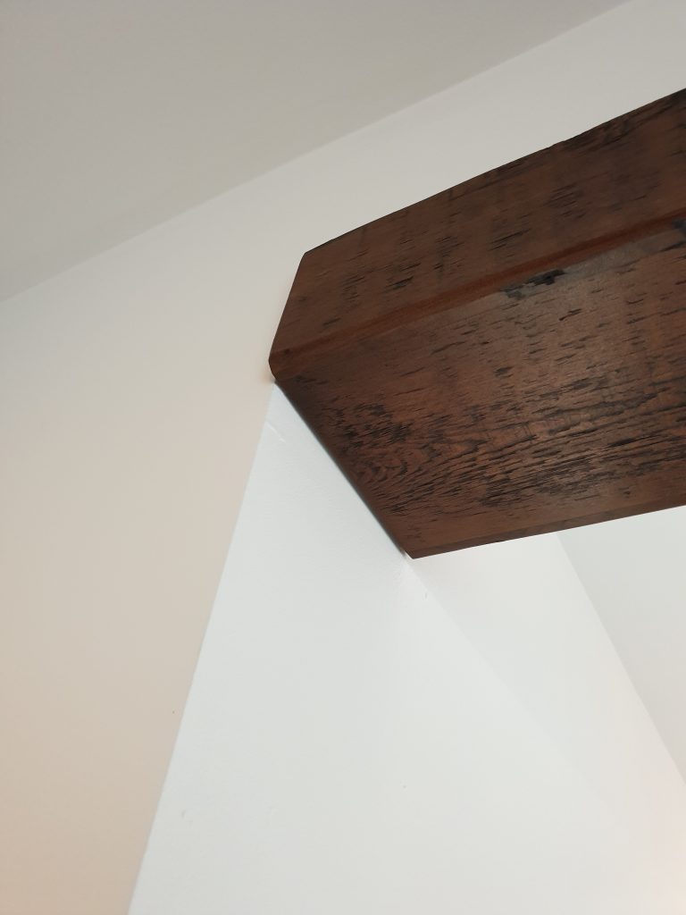 The reclaimed wood beam made to fit in with the rest of the kitchen