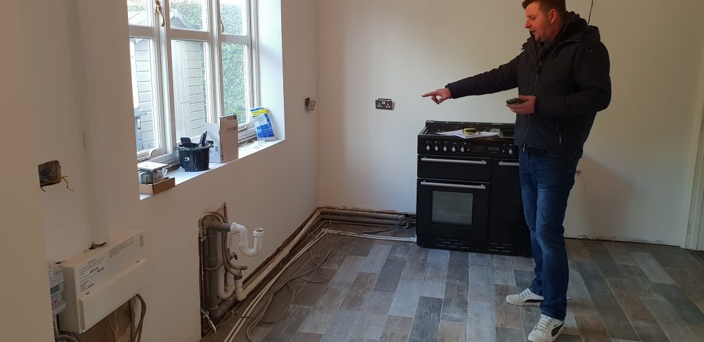 Inspecting kitchen before installation of new reclaimed wood units