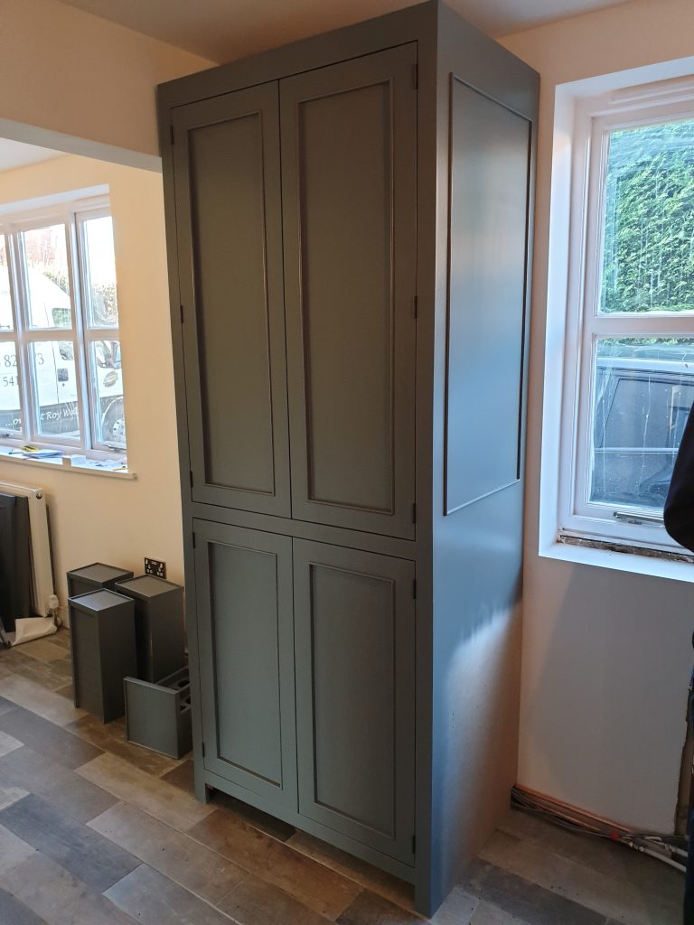 Installation of tall reclaimed wood larder cupboard 