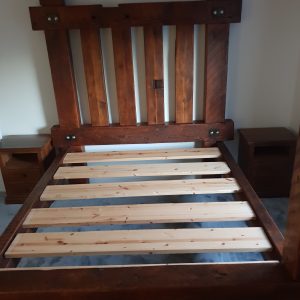 A rugged viking bed made from reclaimed wood, with a heavy-duty, rustic finish that highlights the unique character and history of the timber.