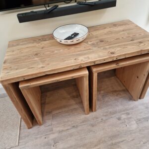 A full view of a rustic nest of tables, with each table positioned slightly apart to display the individual sizes and the unique character of the reclaimed wood. The natural knots and grain are visible, emphasizing the handcrafted and rustic aesthetic of the set.