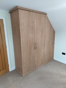 A bespoke fitted wardrobe with a minimalist design, built to fit an entire wall