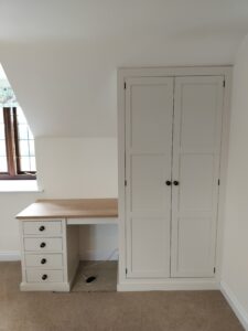 A close-up view of a bespoke fitted wardrobe interior, showing custom drawers and shelving.