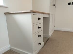 A bespoke fitted wardrobe drawer open, showing custom-made internal dividers