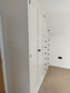 The interior of a bespoke fitted wardrobe, showcasing various shelving and cabinet compartments