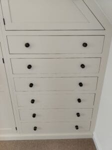 The interior of a bespoke fitted wardrobe, showcasing various shelving and drawer configurations